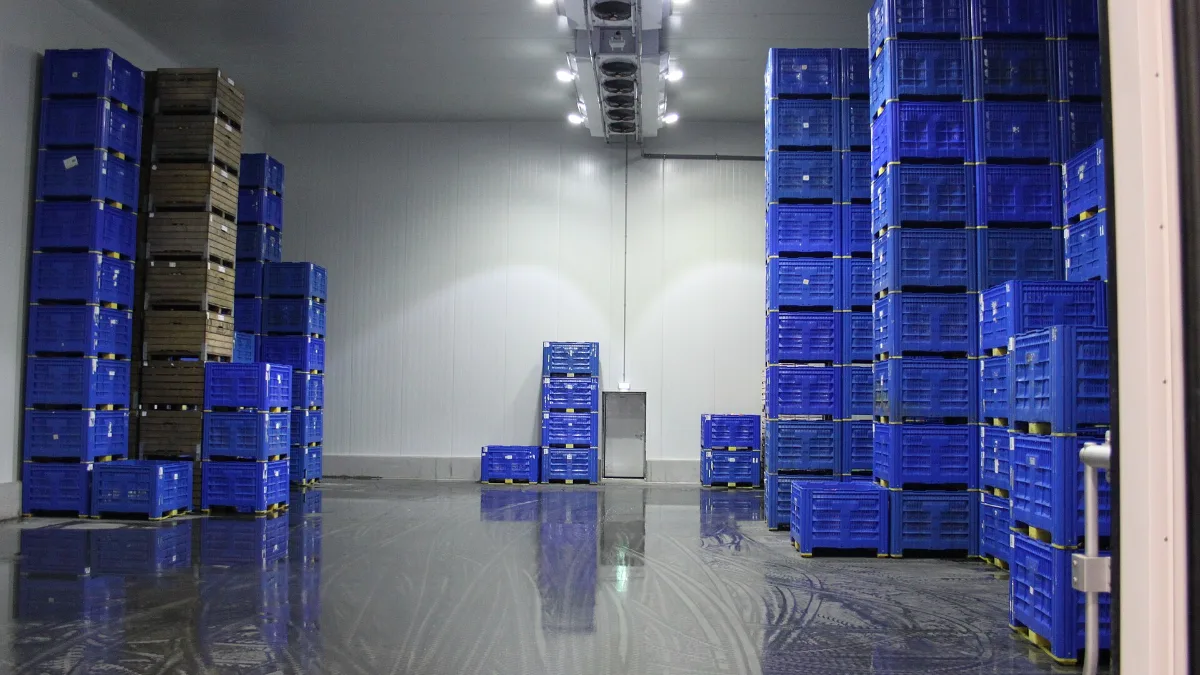 Interior de una cámara frigorífica con cajas de plástico apiladas