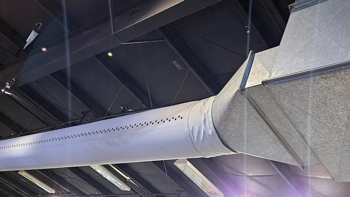Ducto metálico de distribución de aire suspendido del techo de una nave